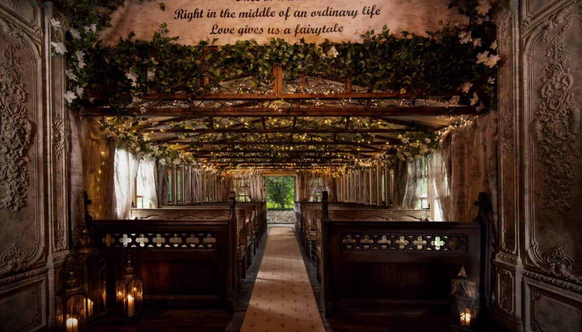 Wood-panelled ceremony room at Branxholm Park with greenery above the aisle