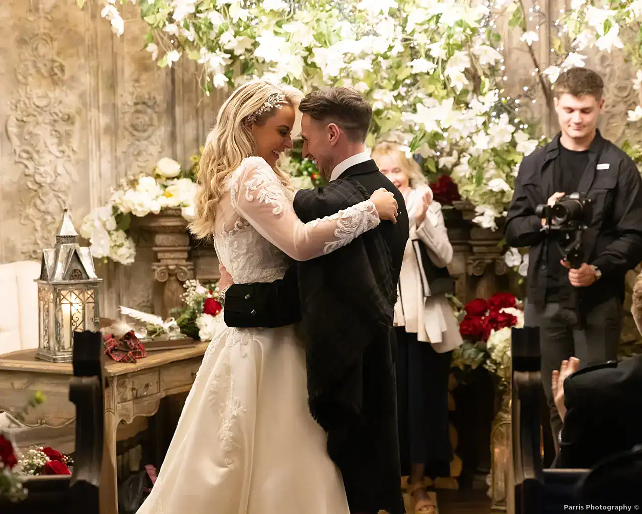Yvonne and John sharing a just-married hug among flowers and fairy lights at Branxholm Park